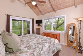 queen size bed overlooking a wooded view