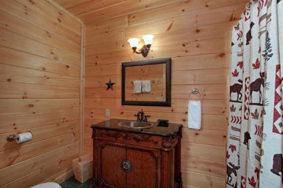 Pigeon Forge Cabin with log bathroom interior featuring a standard tub/shower