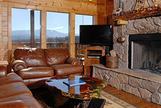 Living room area with a fireplace overlooking the kitchen and dinning area and a mountain view