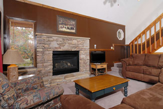 Pigeon Forge Chalet With microfiber Couches in the Living Room Area that has a Gas Fireplace