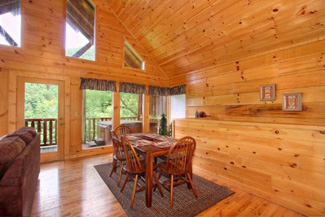 Living Room and dining area is an open floor plan area with lofted ceilings and surrounded in wood features