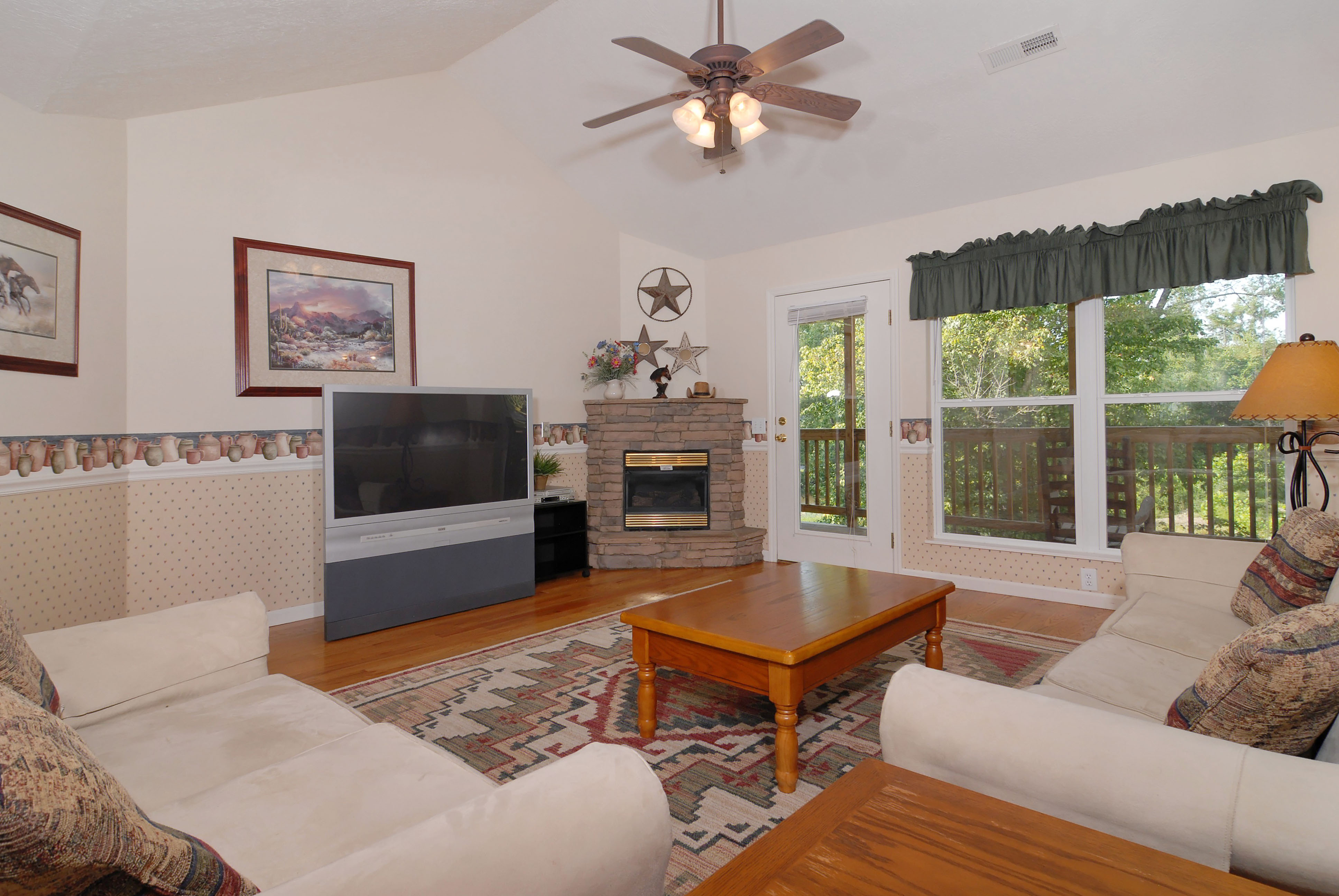 River Cottage Rental that features a fireplace, tv, seating area, and a door leading to the outdoor river deck