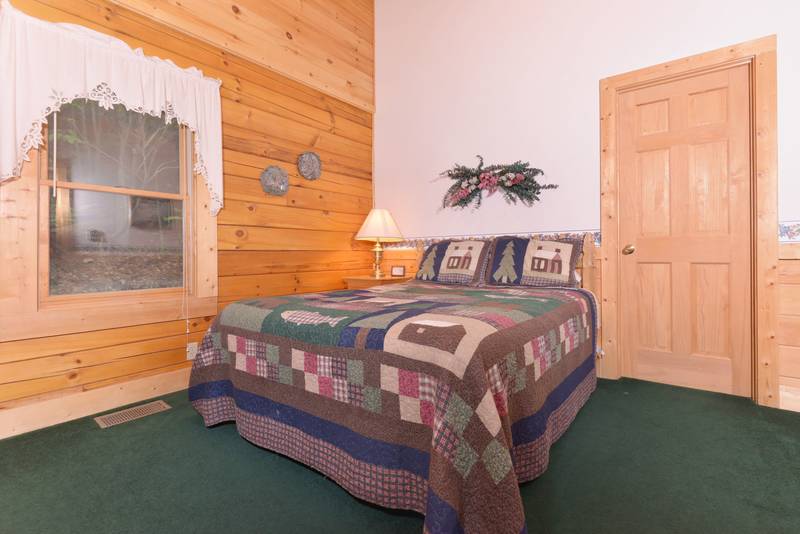 Pigeon Forge Two Bedroom Cabin Main Level Bedroom featuring a queen size bed and television