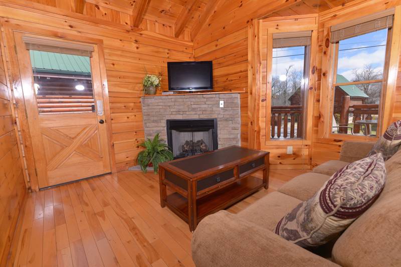 Pigeon Forge Cabin Rental Living Room Area that features a gas fireplace-flat screen television-sleeper sofa