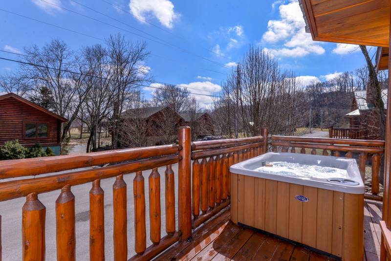 Pigeon Forge Cabin Rental featuring a hot tub on the deck near the Little Pigeon River