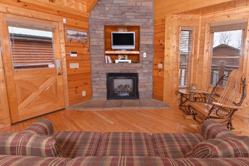 Pigeon Forge Cabin Rental Living Room Area that features a gas fireplace-flat screen television-sleeper sofa