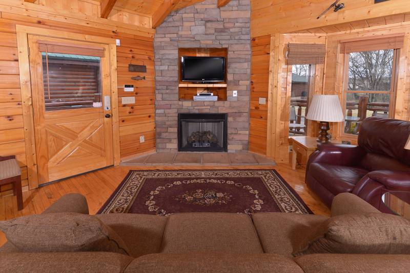 Pigeon Forge Cabin Rental Living Room Area that features a gas fireplace-flat screen television-sleeper sofa