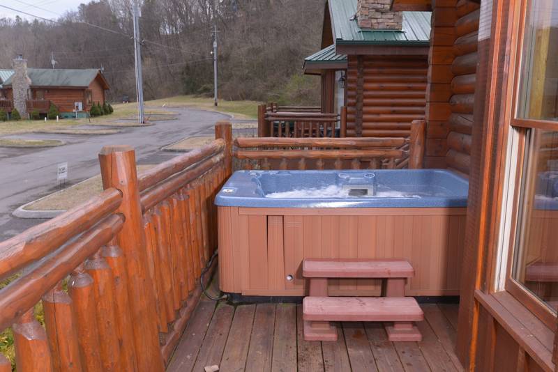 Pigeon Forge Cabin Rental featuring a hot tub on the deck near the Little Pigeon River