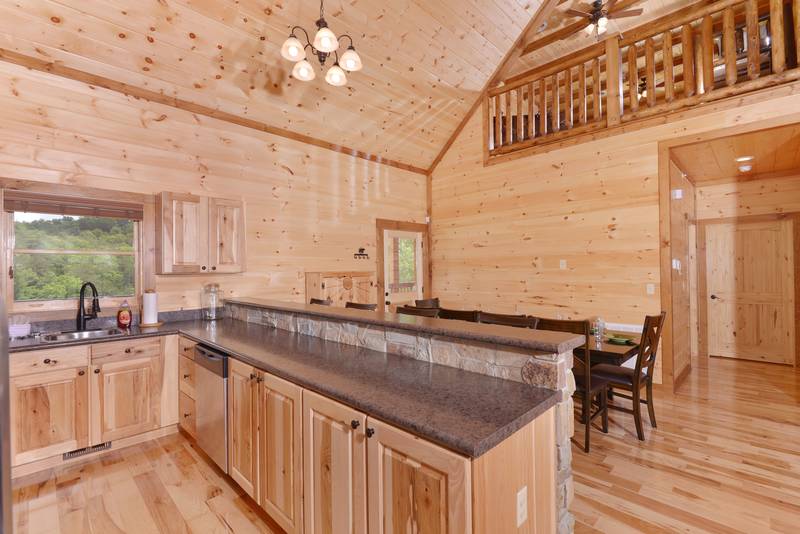 The fully equipped kitchen is lofted looking into the upstairs area and into the main level living area