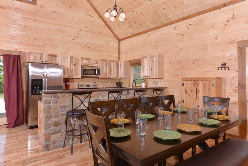 Enjoy the open feel of this luxury three bedroom cabin rental dinning and kitchen area