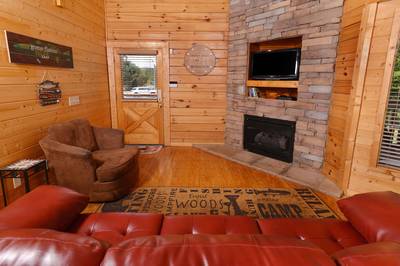 River Cabin living room with stone encased gas log fireplace