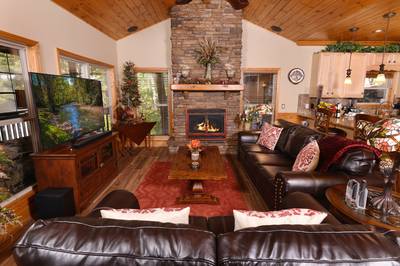 Crystal Waters main level living room with stone encased gas log fireplace