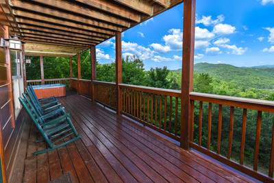 Getaway Mountain Lodge lower level covered wraparound deck with hot tub and rocking chairs