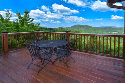 Getaway Mountain Lodge main level wraparound deck with metal table and chairs