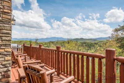 A Cabin of Dreams wrap around deck with rocking chairs