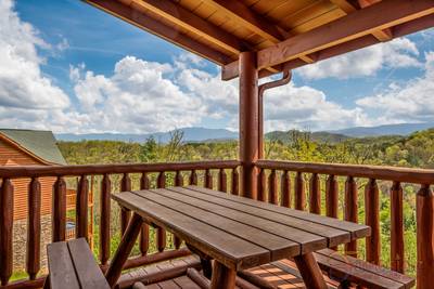 A Cabin of Dreams covered deck with picnic table