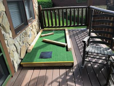 Three Bears lower level covered back deck with putt putt course and rocking chairs