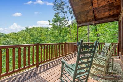 A Walk in the Cloud lower level covered back deck with mountain views