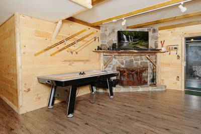 Under Ober living room with air hockey table and wood burning fireplace