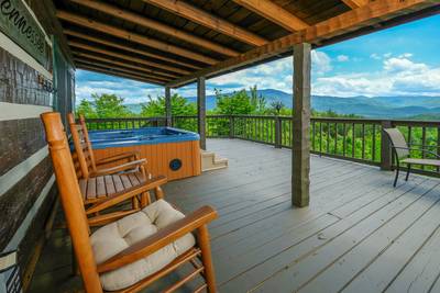 Secluded Summit covered front deck with rocking chairs and hot tub