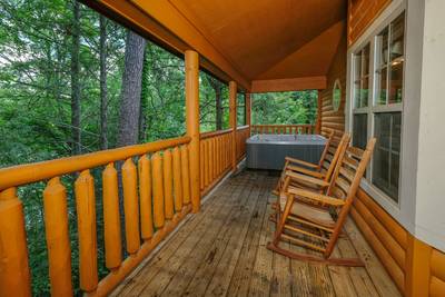 Timber Tree Lodge covered back deck with rocking chairs and hot tub