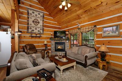 Mountain Magic living room with stone encased seasonal gas fireplace