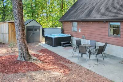 Fuzzy Bear fenced in back yard with hot tub and table and chairs