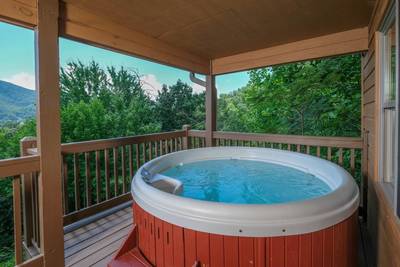 Bearfootin covered back deck with hot tub