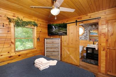 My Pigeon Forge Cabin main level bedroom 1 with 50-inch flat screen TV