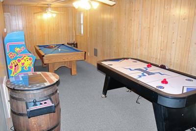 Alluring River lower level game room with arcade machines, pool table, and air hockey table