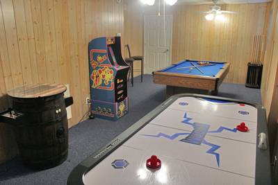 Alluring River lower level game room with arcade machines, pool table, and air hockey table