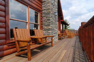 A Cabin of Dreams main level wrap around deck with rocking chairs