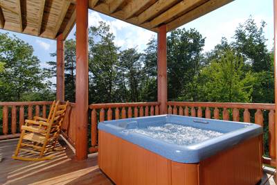 A Cabin of Dreams covered deck with hot tub