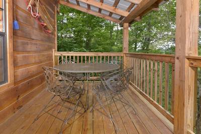Beary Beary Special main level covered back deck with metal table and chairs