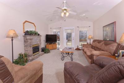 River Escape living room with stone encased seasonal gas log fireplace